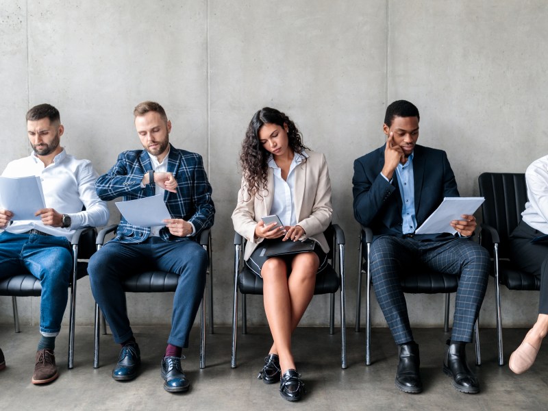 Prospective new hires sitting in line for a job.