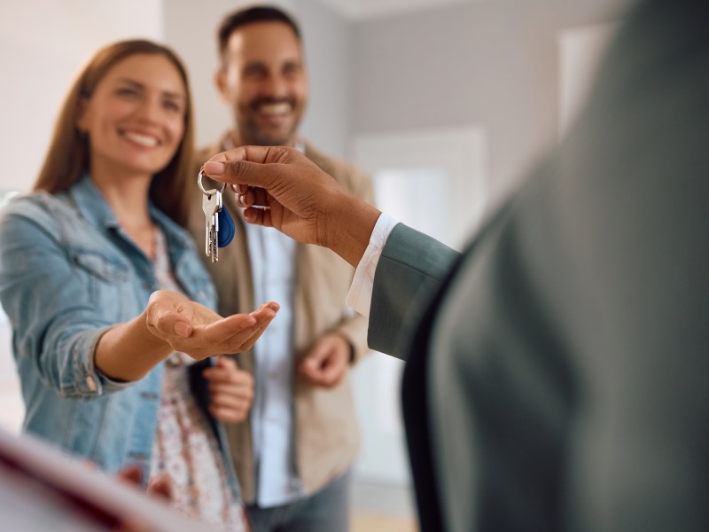 Close up of happy couple recieiving keys to their new house.