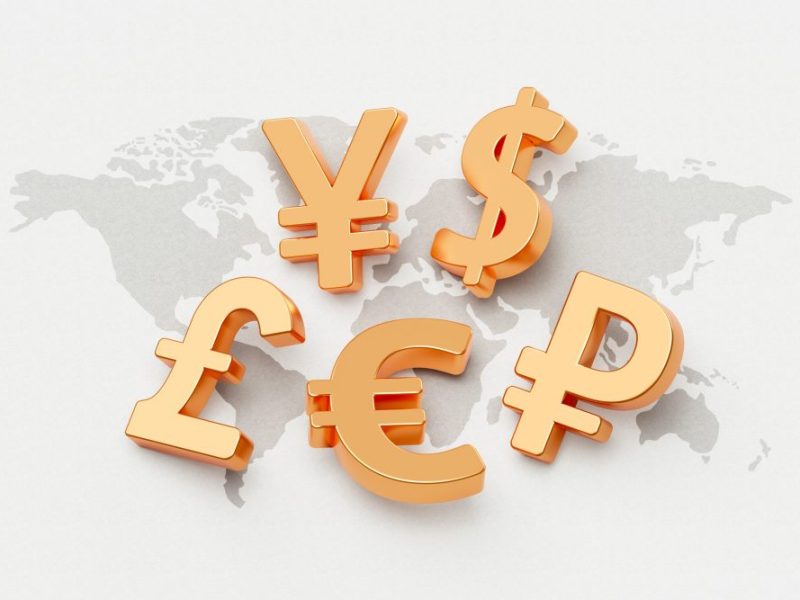 Multiple different crrency symbols over a map of the world.