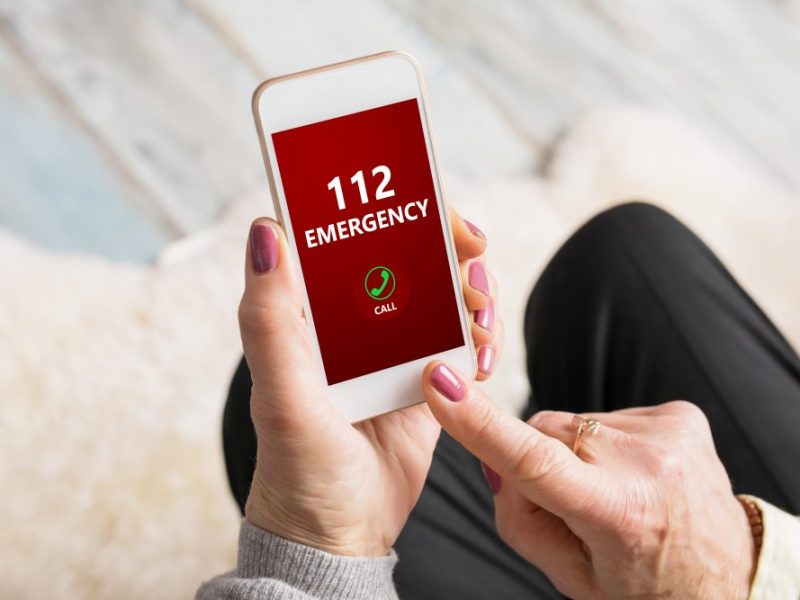Old woman dialing emergency number 112 in costa del sol spain.