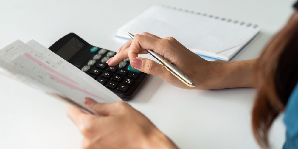 Woman using a calculator to calculate the cost of owning property in costa del sol.