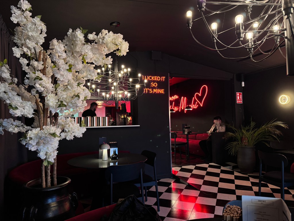inside a restaurant with white flowers and black walls